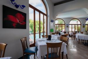 a restaurant with white tables and chairs and windows at Grand Hotel Excelsior in San Benedetto del Tronto