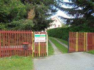 a gate with a sign on it in front of a house at Penzion Šerhant in Zahořánky
