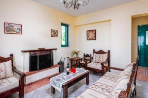a living room with couches and a fireplace at Anemos Villa in Sálakos