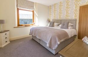 um quarto com uma cama grande e uma janela em Grizedale View em Coniston