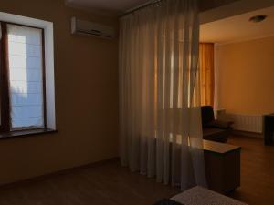 a living room with a chair and a window at Veranda Guest House in Chornomorsk