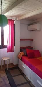 - une chambre avec un lit rouge et une fenêtre rose dans l'établissement Vivienda rural fuente de los gusarapos, à Burunchel