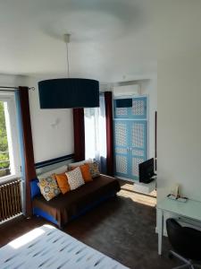 a living room with a couch and two windows at Chambres d'Hôtes Les Muriers in Romans-sur-Isère