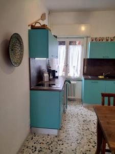 a kitchen with blue cabinets and a table and a tableablish at Casa Lago Azzurro Apartement in Cannobio +21 photos