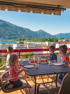 ロカルノにあるApart Holidays - Residenza Floraの食卓に座って食べる子供たち