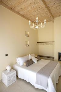 Un dormitorio con una cama grande y una lámpara de araña. en Perlage Suite Luxury B&B - Amazing view of Trulli en Alberobello