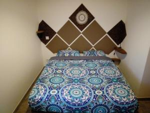 a bedroom with a bed with a blue and white bedspread at O Nosso Lar in Lagos