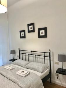 a bedroom with two beds and three pictures on the wall at La camera in centro ( 1 minute from Piazza Unita) in Trieste