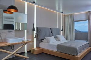 1 dormitorio con cama, escritorio y ventana en Kosmoplaz Beach Hotel en Platis Gialos