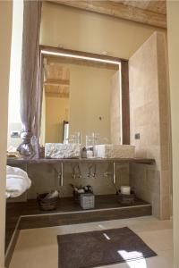 baño con lavabo y espejo grande en Perlage Suite Luxury B&B - Amazing view of Trulli, en Alberobello