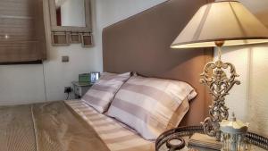a bedroom with a bed with a lamp on a table at Estia, Cozy & Stylish Villa - Elani in Siviri