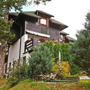 a large house with a tree in front of it at Vila Jelena, Tara in Kaludjerske Bare