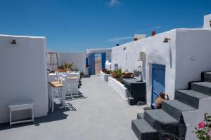 a corridor of white buildings with tables and chairs at Labyrinth Traditional Houses in Pyrgos