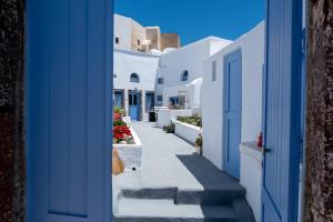 a hallway of white buildings with a blue door at Labyrinth Traditional Houses in Pyrgos