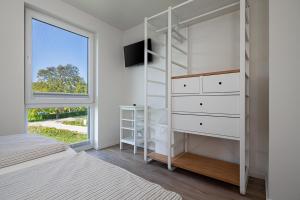 トレントにあるFerienhaus Rügen-Relaxのベッドルーム(白い二段ベッド1組、窓付)