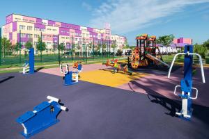 a playground in a park with a large building at Fioleto Ultra All inclusive Family Resort In Miracleon in Anapa