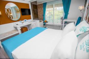 1 dormitorio con cama, lavabo y espejo en Ocean Blue High Class Hotel & SPA, en Ölüdeniz