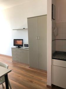 a room with a kitchen with a tv and a cabinet at Residence Principi di Piemonte in Alassio