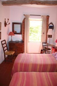 a bedroom with a bed and a dresser and a window at Sous l'abricotier in Durban-Corbières