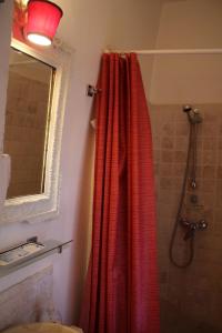 a bathroom with a shower with a red shower curtain at Sous l'abricotier in Durban-Corbières