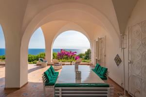 a dining room with a table and chairs and the ocean at Il Carrubo Capri in Anacapri