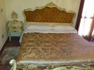 una camera da letto con un grande letto con copriletto dorato di Ca' Bianca a Lugo