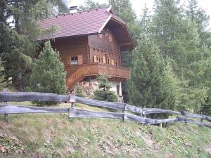 ein Haus auf einem Hügel mit einem Zaun davor in der Unterkunft FELBER Hüttn in Patergassen