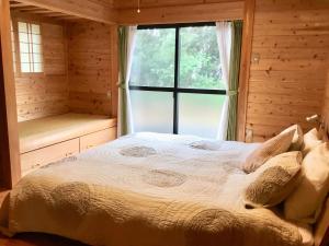 a bedroom with a large bed and a window at South Coast house in Yakushima +9 photos