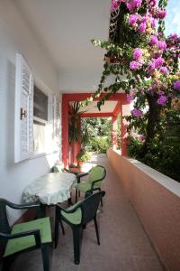 un patio con mesa, sillas y flores en Stela Apartments, en Trogir