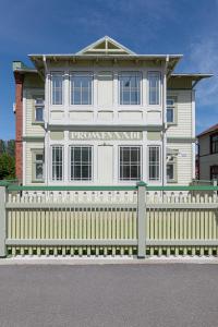 a white house with a fence in front of it at Promenaadi Villa in Pärnu