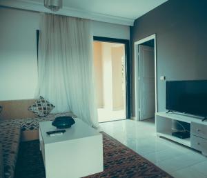 a living room with a flat screen tv and a couch at Pool View One bedroom Apt - B103 in Hurghada