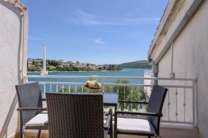 a balcony with chairs and a view of the water at Apartments Ana Bilota in Seget Vranjica