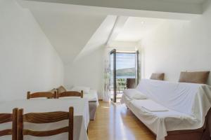 ein weißes Zimmer mit 2 Betten und einem Sofa in der Unterkunft Apartments Ana Bilota in Seget Vranjica