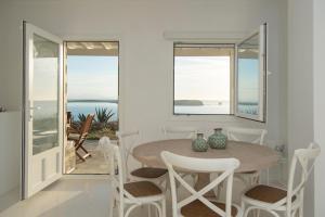 a white dining room with a table and chairs at Meltemi Seaside in Kampos Paros