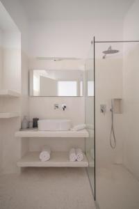 een witte badkamer met een wastafel en een douche bij Meltemi Seaside in Kampos Paros