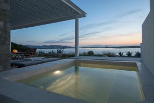 een zwembad in een huis met uitzicht op het water bij Meltemi Seaside in Kampos Paros