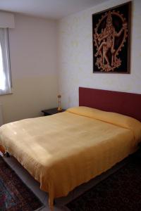 a bedroom with a bed with a painting on the wall at LORELY in Udine