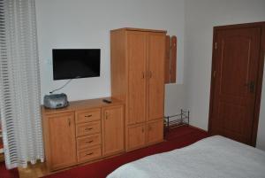 um quarto com uma televisão numa cómoda com uma cama em Pokoje z łazienkami em Kolobrzeg