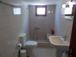 a white bathroom with a toilet and a sink at Sofirene Sea Scape in Batsi +35 photos