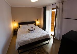 un dormitorio con una cama con un animal de peluche en Beachfront stylish maisonette in Ierissos en Ierissos