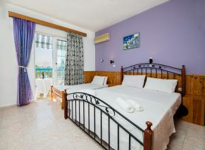 a bedroom with two beds and a large window at Poseidon Apartment in Archangelos