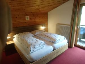 a bedroom with a bed with a wooden wall at Pension Alpenstern in Oberau