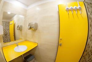 Baño amarillo con lavabo y espejo en SEÑOR OSO, en Molinaseca
