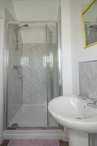 a white bathroom with a shower and a sink at The Saracens Head THE CONKERA in Chapel Saint Leonards