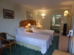 a hotel room with a bed and a desk at The Red Lion Tavern in Fochabers