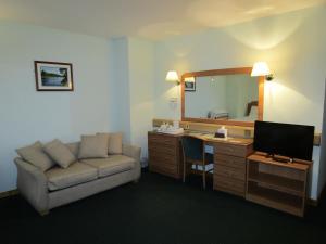 a room with a couch and a desk with a mirror at The Red Lion Tavern in Fochabers