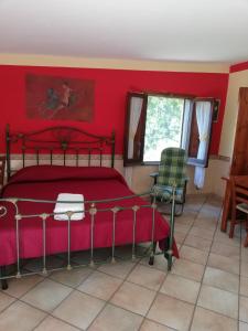 - une chambre dotée d'un lit avec un mur rouge dans l'établissement Pietramiliare, à Trecase