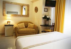 a bedroom with a bed and a chair and a mirror at Locanda A Cà Du Gigante in Monterosso al Mare