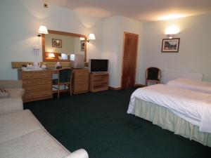 a bedroom with a bed and a dresser at The Red Lion Tavern in Fochabers