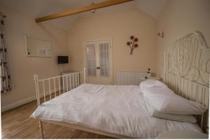 una camera con un letto bianco e pavimenti in legno di Saracens Head Old Function Room a Chapel Saint Leonards